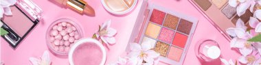 Spring professional makeup flat lay. Spring make up set on pink background. Different make-up cosmetics, beauty accessories flat lay with spring blossom flowers top view copy space 