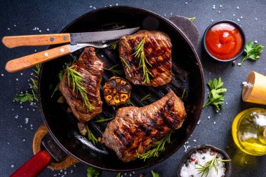 Bitki ve baharatlı ızgara biftek. Biberiye, sarımsak, zeytinyağı ve ketçap soslu kızarmış et.