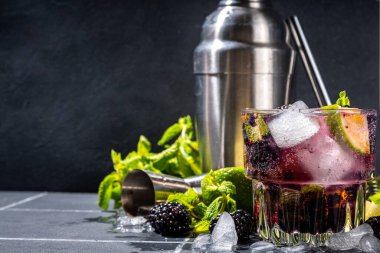 Böğürtlenli limonata ya da limonlu mojito ve nane. Buzlu taze yaz kokteyli, böğürtlen, limon, miint ve buz. Koyu renkli arkaplan kopyalama alanı