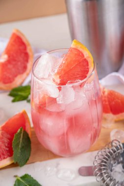 Greyfurtlu margarita ya da soğuk şampanyalı limonata kokteyli. Yaz kokteylini, bir parça greyfurt ve nane şekeriyle bar aletleri ve malzemeleriyle tazeliyorum.