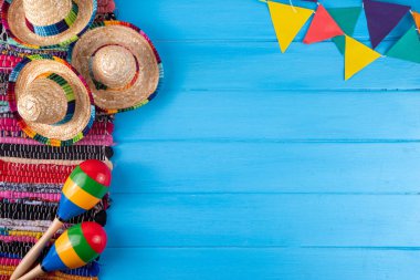 Meksika bayramı arkaplanı, serape çizgili battaniye veya panço şapkası, eski mavi ahşap arka planda marakas. Meksika Cinco de Mayo festivali, Meksika Bağımsızlık Günü geçmişi