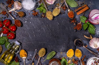 Karanlık arka planda yemek pişirmek için baharatlar. Farklı baharatlar, baharatlar ve otlar kırmızı biber, zerdeçal, tuz, fesleğen, nane, tarçın, sarımsak, zeytinyağı, hazır yemek için aromatik malzemeler.