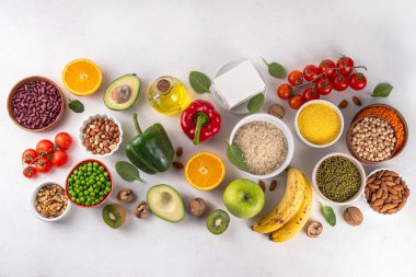 Portföy diyeti, fındık, sebze proteini, bitki sterolleri, yapışkan lif, fasulye, baklagiller, taze sebzeler ve beyaz arka plandaki meyveler dahil olmak üzere dengeli kolesterol vejetaryen gıdalar.