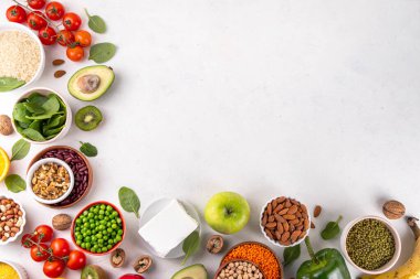 Portföy diyeti, fındık, sebze proteini, bitki sterolleri, yapışkan lif, fasulye, baklagiller, taze sebzeler ve beyaz arka plandaki meyveler dahil olmak üzere dengeli kolesterol vejetaryen gıdalar.