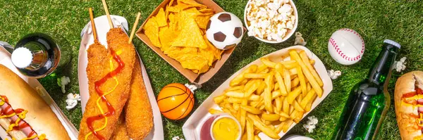 Traditional sport stadium foods and beer background, Set of various baseball, basketball, football fans and stadium snacks, chips, sauces, hot dogs with beer bottles and fan accessories