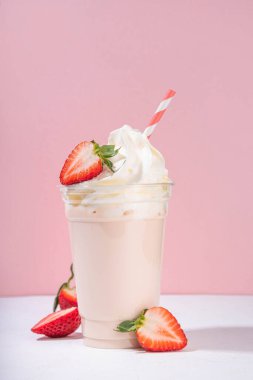 Çilekli milkshake veya smoothie, taze çilekli yaz meyve kokteyli, beyaz pembe arka plan, bar menüsü afişi veya arka plan, kafe içkileri maketi