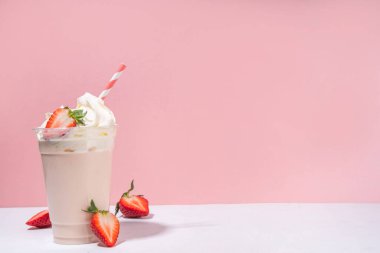 Çilekli milkshake veya smoothie, taze çilekli yaz meyve kokteyli, beyaz pembe arka plan, bar menüsü afişi veya arka plan, kafe içkileri maketi