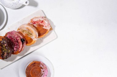 Çeşitli yuvarlak kruvasanlar, poğaça New York Roll, Supreme Croissants, farklı malzemeler ve dolgu malzemeleriyle donatılmış Moda Tatlı Pastalar.