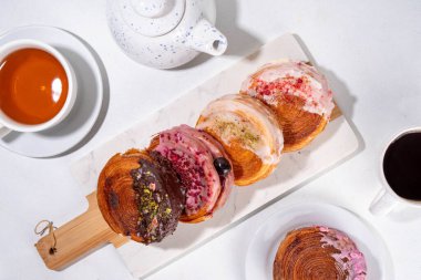 Çeşitli yuvarlak kruvasanlar, poğaça New York Roll, Supreme Croissants, farklı malzemeler ve dolgu malzemeleriyle donatılmış Moda Tatlı Pastalar.