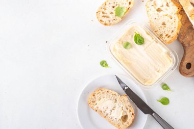 Ev yapımı vegan yağı, sütsüz krema, soya fasulyesi izinli alternatif tereyağı ve mutfak masasının arkasında ev yapımı ekmek.