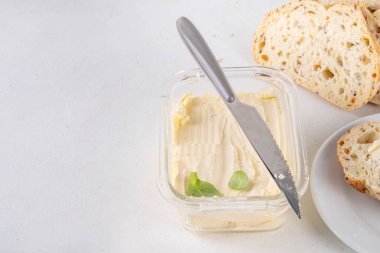 Ev yapımı vegan yağı, sütsüz krema, soya fasulyesi izinli alternatif tereyağı ve mutfak masasının arkasında ev yapımı ekmek.