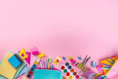 Okul ekipmanları parlak pembe düz yerde yatıyordu. Çeşitli okul ve ofis malzemeleri, aksesuarlar. Okul satışına geri dön. Üst görünüm kopyalama alanı