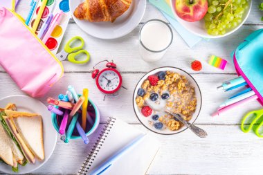 Okul çocukları için sağlıklı besleyici bir sabah kahvaltısı, taze meyve, sebze, kruvasan, müsli, süt ve sandviç. Okuldan ve işten önce kahvaltı yapmak, fotokopi çekmek.