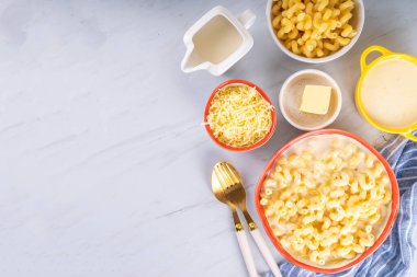 Pişirmek için malzemeli kremalı makarna ve peynir. Makarna, beşamel krem sos, süt, peynir beyaz mermer mutfak masasında makarna yapmak için.