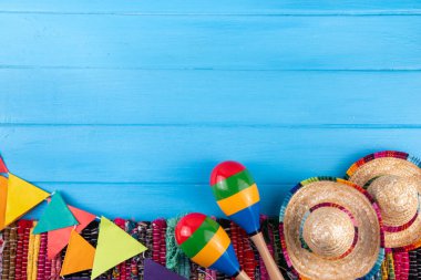 Meksika bayramı arkaplanı, serape çizgili battaniye veya panço şapkası, eski mavi ahşap arka planda marakas. Meksika Cinco de Mayo festivali, Meksika Bağımsızlık Günü geçmişi