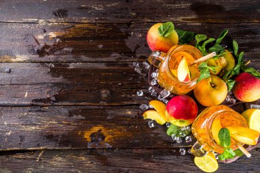 Taze ev yapımı şeftali, naneli ve limon dilimli tatlı çay, soğuk yaz meyveli içecek. Taze şeftalili ahşap zemin, kopyalama alanı