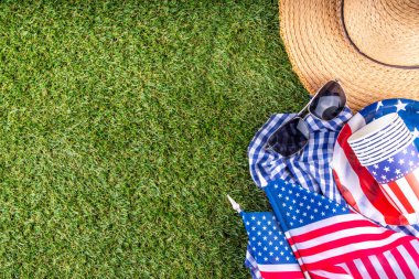 4 Temmuz, Bağımsızlık Günü geleneksel Amerikan piknik geçmişi. Tabaklar, bardaklar, yeşil çimenlik ya da çayır çimenliğindeki Amerikan bayrakları, piknik için battaniye ya da masa örtüsü, güneş gözlüğü, fotokopi alanı üst görünümü