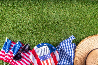 4 Temmuz, Bağımsızlık Günü geleneksel Amerikan piknik geçmişi. Tabaklar, bardaklar, yeşil çimenlik ya da çayır çimenliğindeki Amerikan bayrakları, piknik için battaniye ya da masa örtüsü, güneş gözlüğü, fotokopi alanı üst görünümü
