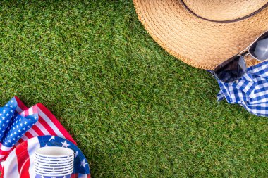4 Temmuz, Bağımsızlık Günü geleneksel Amerikan piknik geçmişi. Tabaklar, bardaklar, yeşil çimenlik ya da çayır çimenliğindeki Amerikan bayrakları, piknik için battaniye ya da masa örtüsü, güneş gözlüğü, fotokopi alanı üst görünümü