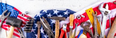 Amerikan Ulusal Vatansever İşçiler Mutlu İşçi Bayramı tatili geçmişi. Ahşap zemin üzerinde yıldızlı inşaat ve imalat araçları, kırmızı beyaz mavi çizgili Amerikan bayrağı
