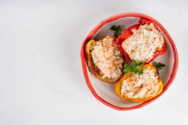 Mutfak arka planında dolma dolma dolma dolma dolma dolma biber. Renkli kırmızı, sarı, yeşil biberli diyet tavuk kıymalı et, sebze ve pirinç, beyaz soslu, dengeli sağlıklı yemek tarifi