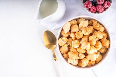 Küçük kahvaltılık kruvasan gevrekleri, taze böğürtlen ve süt. Fırında taze, ahududu ve yaban mersinli mini ay çöreği ile porsiyonlar, tatlı sabah atıştırması.