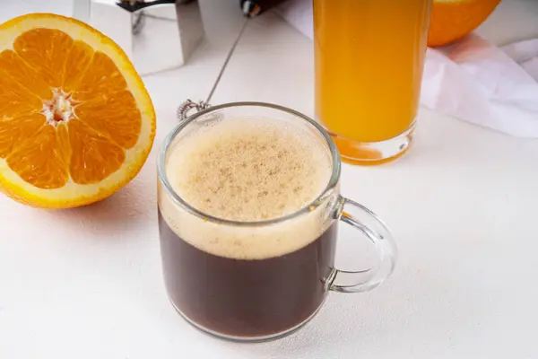 カプオレンジの夏のコーヒードリンク ホワイトテーブルのコピースペースにオレンジジュースが入ったブラックコーヒー ロイヤリティフリーのストック写真