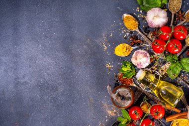 Karanlık arka planda yemek pişirmek için baharatlar. Farklı baharatlar, baharatlar ve otlar kırmızı biber, zerdeçal, tuz, fesleğen, nane, tarçın, sarımsak, zeytinyağı, hazır yemek için aromatik malzemeler.