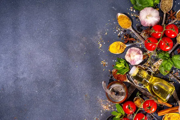 Spices for cooking on dark background . Different seasonings, spices and herbs paprika, pepper, turmeric, salt, basil, mint, cinnamon, garlic, olive oil, aromatic ingredients for preparation food