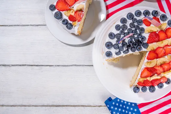 フラグとベリーと7月のケーキの4日 自家製愛国的なアメリカ国旗ストライプバニラクリームスポンジケーキ ホリデーパーティー夏のデザート ロイヤリティフリーのストック画像