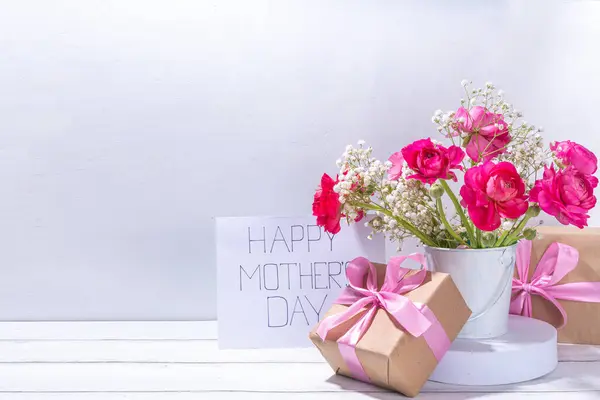 母の日の挨拶カード 招待状の背景 美しいランヌクルスの花の春の花束 かわいいクラフト紙のギフト弓と注意してください幸せな母の日 白い背景にスペースをコピー ロイヤリティフリーのストック写真