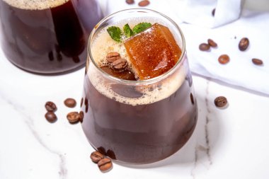 Soğuk Brew Coffee Espresso Carajillo Kokteyli, donmuş espresso buzlu, koyu sade kahve, likör ve votka, beyaz mutfak masasının arka planında fotokopi alanı.