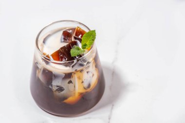 Koyu espresso kahvesi, jelatin ya da agar ve krema ile yapılmış jöleli kahve. Asya soğuk kahve tatlısı kohii zerii kanten beyaz masa arkaplan fotokopi alanı