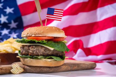 Lezzetli çizburger, patates kızartması ve soslu vatansever Amerikan bayrağı. 4 Temmuz, Bağımsızlık Günü piknik yemeği, ABD temalı bbq hamburger fotokopi alanı