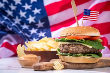 Lezzetli çizburger, patates kızartması ve soslu vatansever Amerikan bayrağı. 4 Temmuz, Bağımsızlık Günü piknik yemeği, ABD temalı bbq hamburger fotokopi alanı