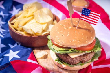 Lezzetli çizburger, patates kızartması ve soslu vatansever Amerikan bayrağı. 4 Temmuz, Bağımsızlık Günü piknik yemeği, ABD temalı bbq hamburger fotokopi alanı