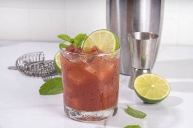 Siyah mol tatlı margarita kokteyli, siyah kakao ya da çikolata şurubu, portakal suyu, mezcal ve soda, modaya uygun alkollü içecek, beyaz arka planda sert ışık ve bar aletleri.