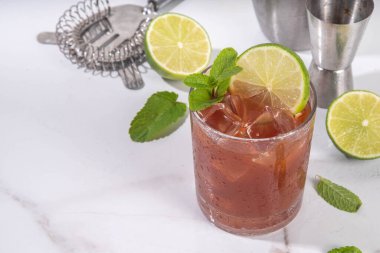 Siyah mol tatlı margarita kokteyli, siyah kakao ya da çikolata şurubu, portakal suyu, mezcal ve soda, modaya uygun alkollü içecek, beyaz arka planda sert ışık ve bar aletleri.