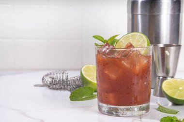 Siyah mol tatlı margarita kokteyli, siyah kakao ya da çikolata şurubu, portakal suyu, mezcal ve soda, modaya uygun alkollü içecek, beyaz arka planda sert ışık ve bar aletleri.