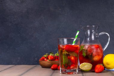 Sürahi ve bardakta ev yapımı çilekli limonata, bir sürü ezilmiş buz, dilimlenmiş böğürtlen ve nane yaprağı, donmuş çilekli sangria, buzlu çay, punç veya mojito ile.