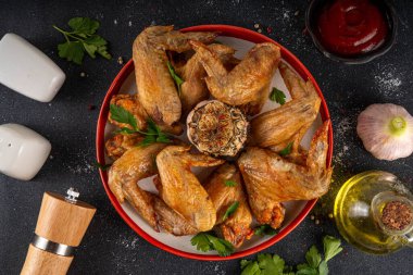Izgara bbq kavrulmuş baharatlı tavuk kanatları ketçap sosu ve baharatlar, ev yapımı barbekü kanatları. 