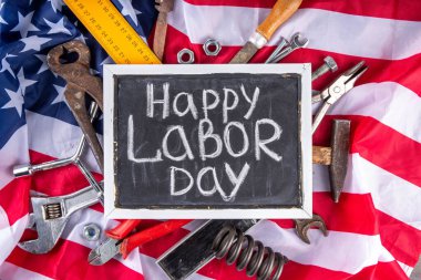 Amerikan Ulusal Vatansever İşçiler Mutlu İşçi Bayramı tatili geçmişi. Ahşap zemin üzerinde yıldızlı inşaat ve imalat araçları, kırmızı beyaz mavi çizgili Amerikan bayrağı