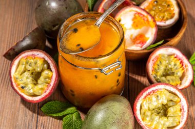 Küçük kavanozda ev yapımı tutku meyvesi reçeli taze tutku meyvesi ve ahşap arka planda nane yaprakları kopyalama alanı.