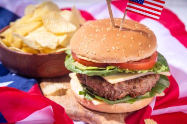 Lezzetli çizburger, patates kızartması ve soslu vatansever Amerikan bayrağı. 4 Temmuz, Bağımsızlık Günü piknik yemeği, ABD temalı bbq hamburger fotokopi alanı