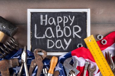 Amerikan Ulusal Vatansever İşçiler Mutlu İşçi Bayramı tatili geçmişi. Ahşap zemin üzerinde yıldızlı inşaat ve imalat araçları, kırmızı beyaz mavi çizgili Amerikan bayrağı