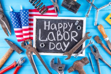 Amerikan Ulusal Vatansever İşçiler Mutlu İşçi Bayramı tatili geçmişi. Ahşap zemin üzerinde yıldızlı inşaat ve imalat araçları, kırmızı beyaz mavi çizgili Amerikan bayrağı