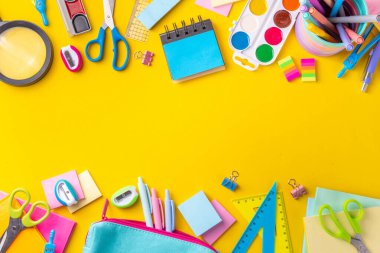 Okul ekipmanları parlak sarı düz yerde yatıyordu. Çeşitli okul ve ofis malzemeleri, aksesuarlar. Okul satışına geri dön. Üst görünüm kopyalama alanı