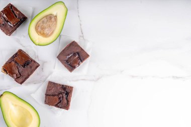 Ev yapımı vejetaryen avokado brownie tatlı, avokado ve kerob ile sağlıklı vejetaryen yemek tatlı, beyaz mutfak masasının fotokopi masası üzerinde.