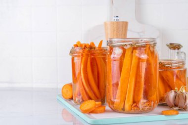 Ev yapımı havuç turşusu, fermente edilmiş havuç, mutfak masasındaki cam kavanozlarda saklanmış konserve sebzeler.