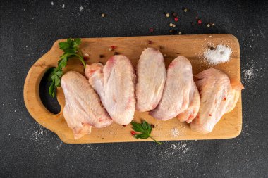 Tavuk kanatları pişirme arka planı çiğ tavuk kanatları, baharatlar ve baharatlar. BBQ, ızgara tavuk eti hazırlama arka plan fotokopi alanı üst görünümü